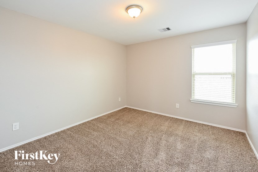 a bedroom with a carpeted floor and a window