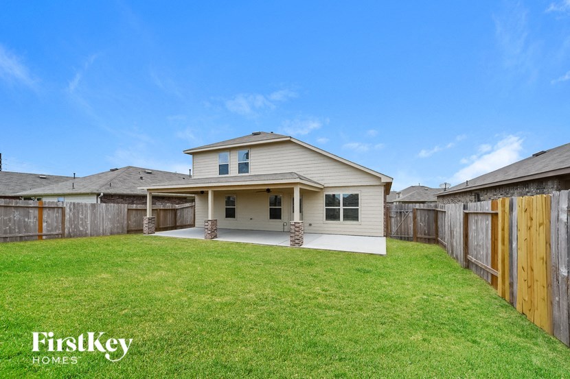a backyard with a house and a grass lawn
