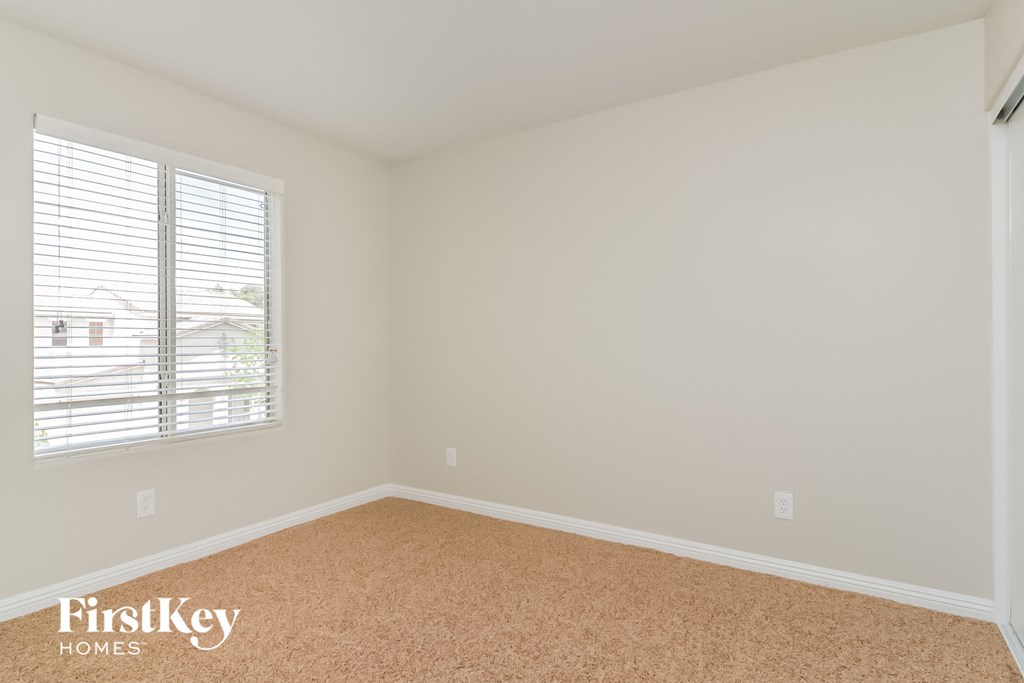 a bedroom with a carpeted floor and a large window