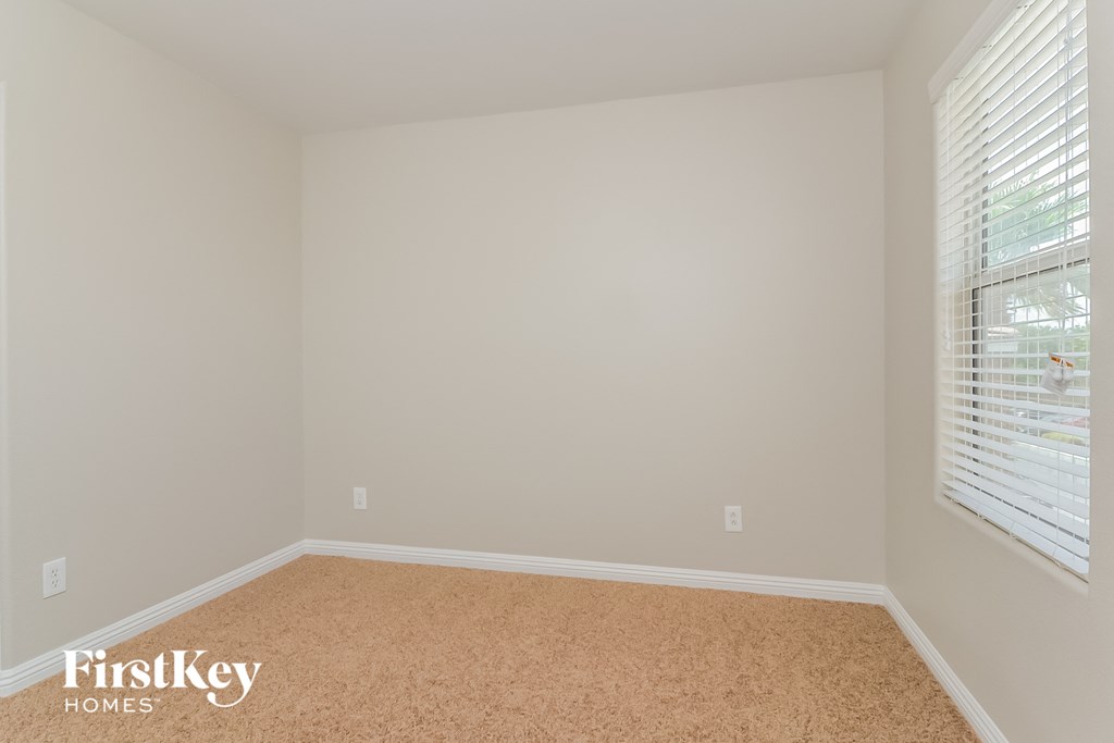 a bedroom with a carpeted floor and a large window
