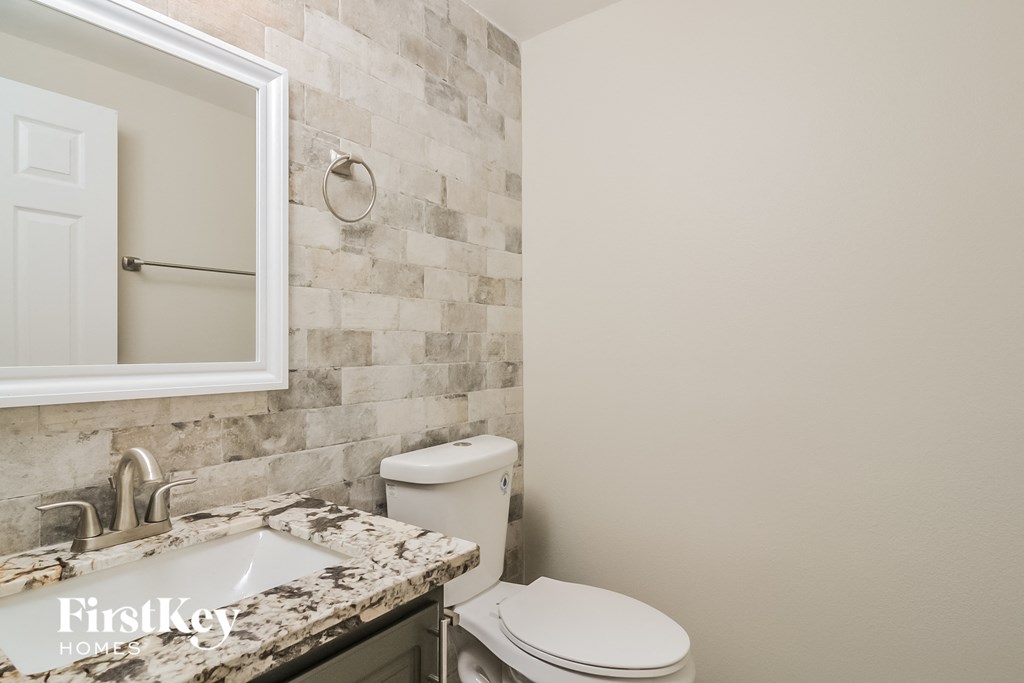 a bathroom with a toilet and a sink and a mirror