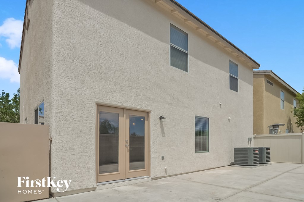 the exterior of a brick building with glass doors and a sidewalk