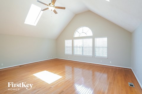 an empty room with a ceiling fan and a window