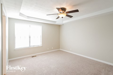 a bedroom with a ceiling fan and a window