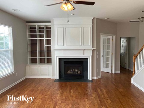 a living room with a fireplace and a bookcase