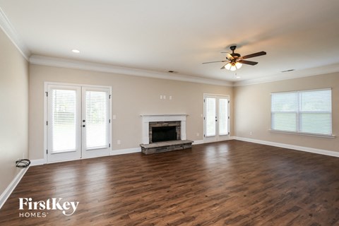a living room with a fireplace and a ceiling fan
