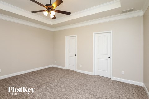 a bedroom with two doors and a ceiling fan