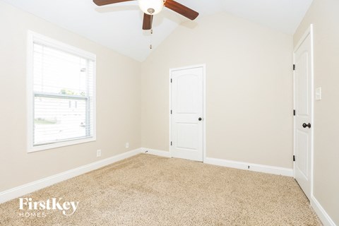 a bedroom with a ceiling fan and a white door