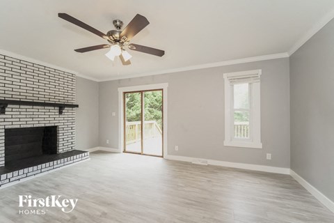 A spacious room with a fireplace and a ceiling fan.