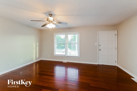 A room with a wooden floor and a ceiling fan.