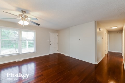 A room with wooden floors and a ceiling fan.