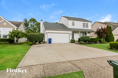 A house with a driveway and a garage door in the front yard.