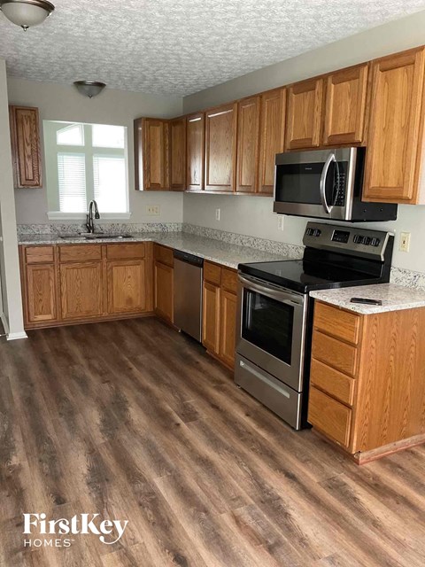a kitchen with wooden cabinets and stainless steel appliances