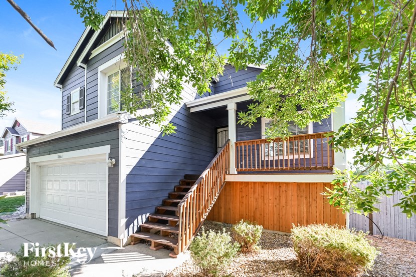 a blue house with a garage door and stairs