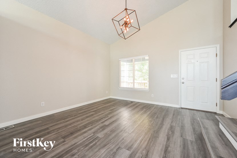 the living room of an empty house with wood flooring