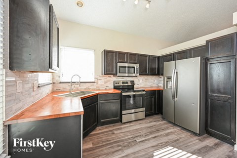 a kitchen with black cabinets and stainless steel appliances