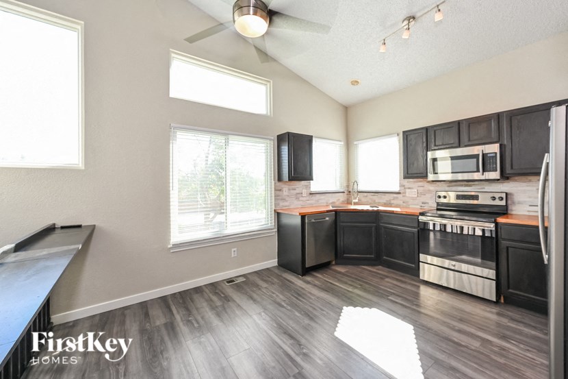 an empty kitchen with black cabinets and stainless steel appliances