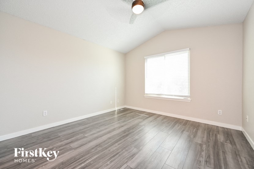 the spacious living room with wood flooring and a large window