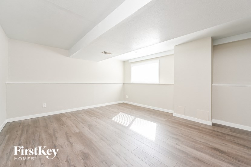 an empty living room with white walls and wood floors
