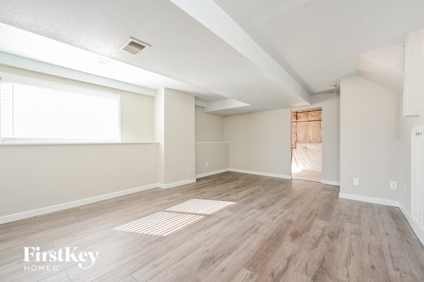 an empty living room with wood flooring and a large window