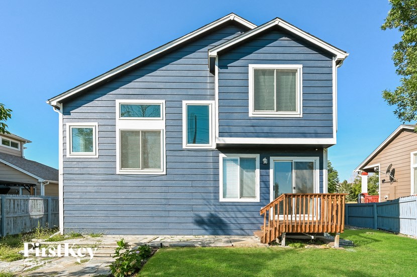 a blue house with a porch and a wooden deck