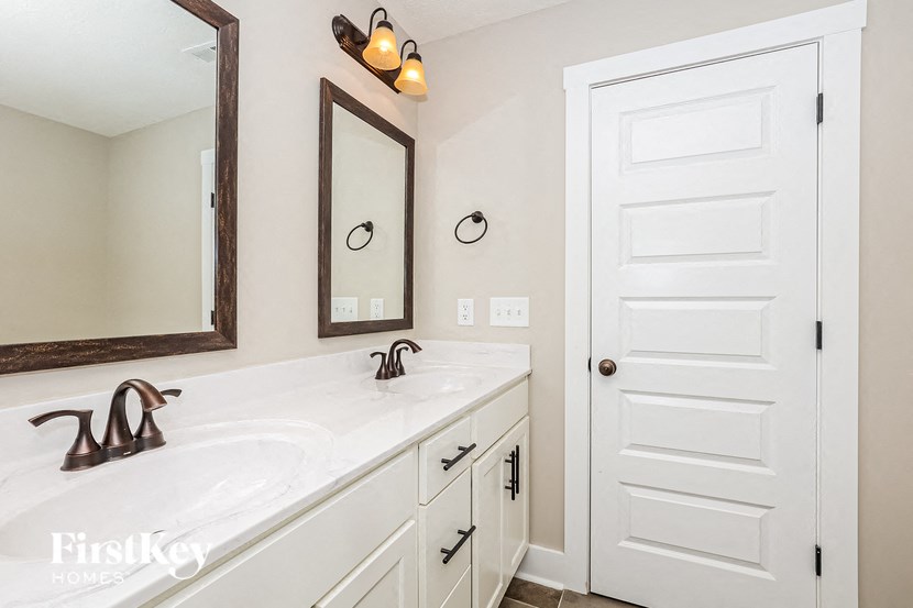 a bathroom with a sink and a mirror and a white door