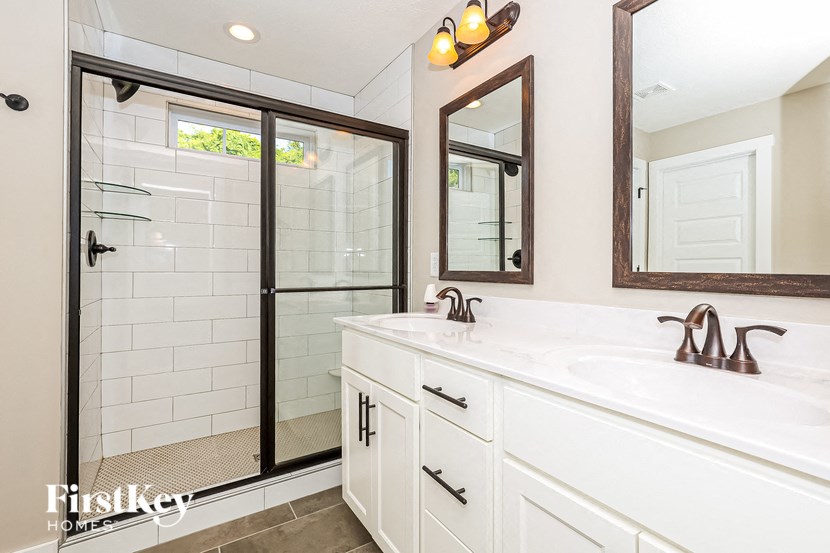 a bathroom with a sink and a shower and a mirror