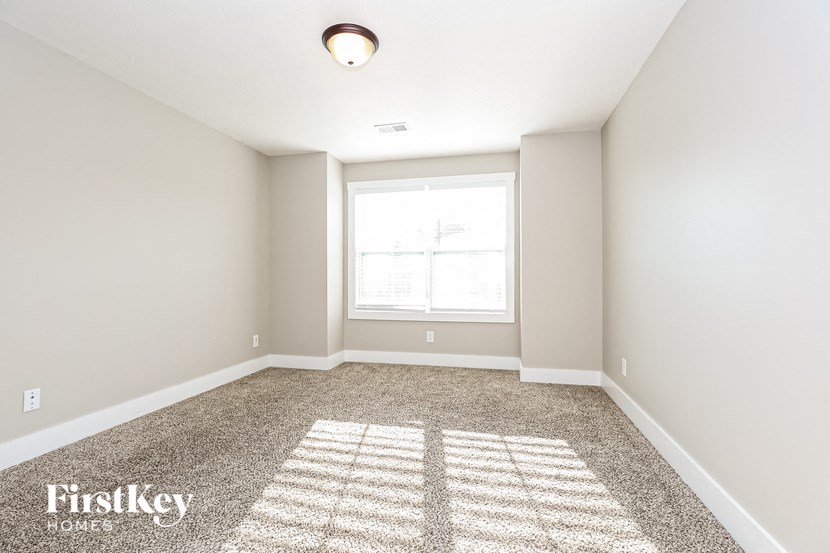 an empty room with a window and carpet