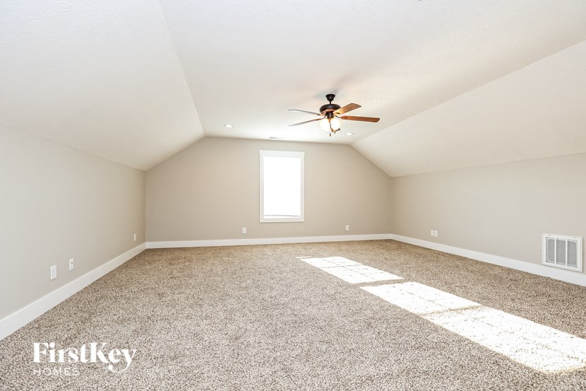 an empty room with a ceiling fan and a window