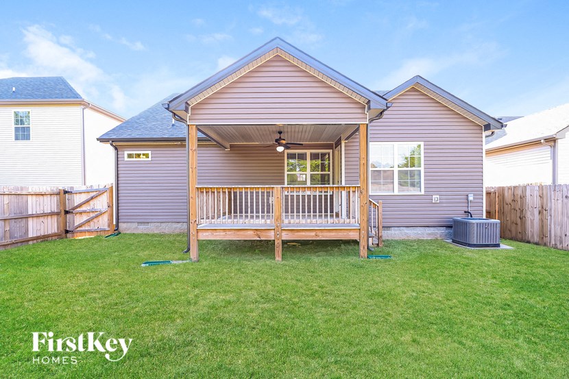a pink house with a porch with a wooden bench