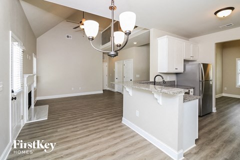 A kitchen with a white island and wooden floors.