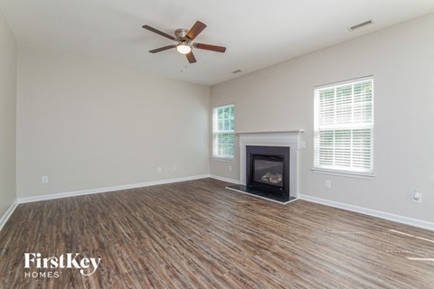 a living room with a fireplace and a ceiling fan