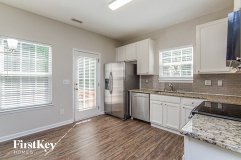 a kitchen with white cabinets and a stainless steel refrigerator
