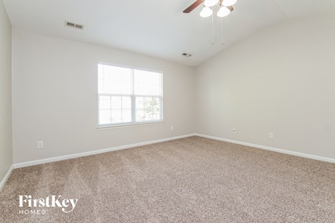 the spacious living room with carpeting and a window
