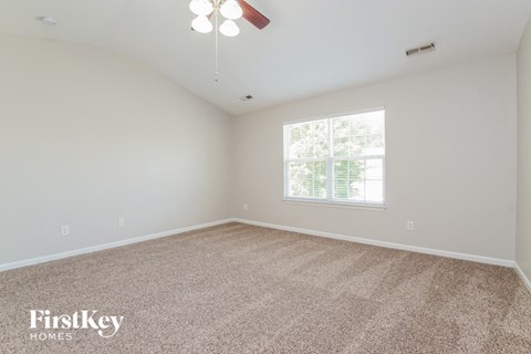 the spacious living room with carpeting and a large window