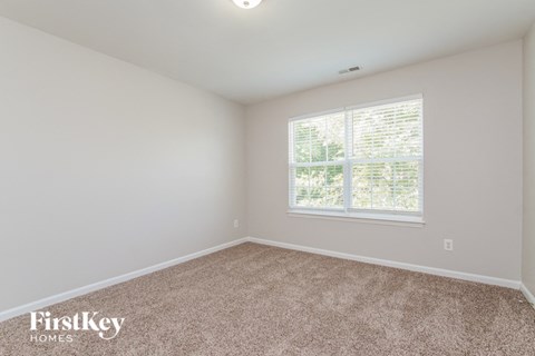 the second bedroom with carpet and a large window