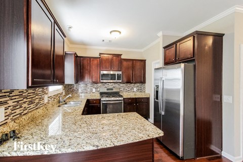 A kitchen with granite countertops and stainless steel appliances.