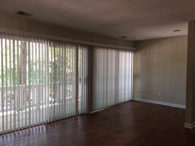 an empty living room with sliding glass doors