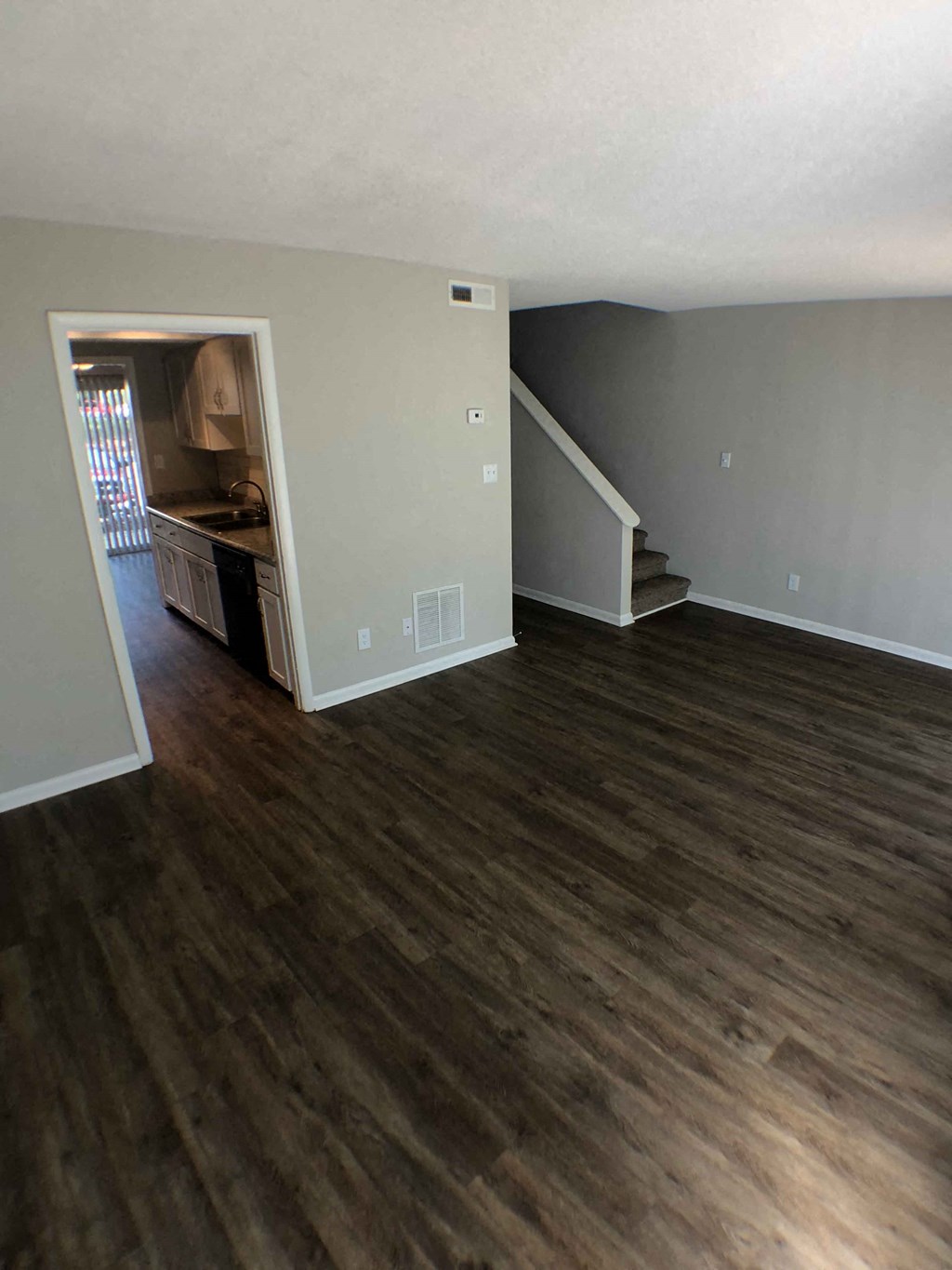 a view of a living room with wood floors and a staircase