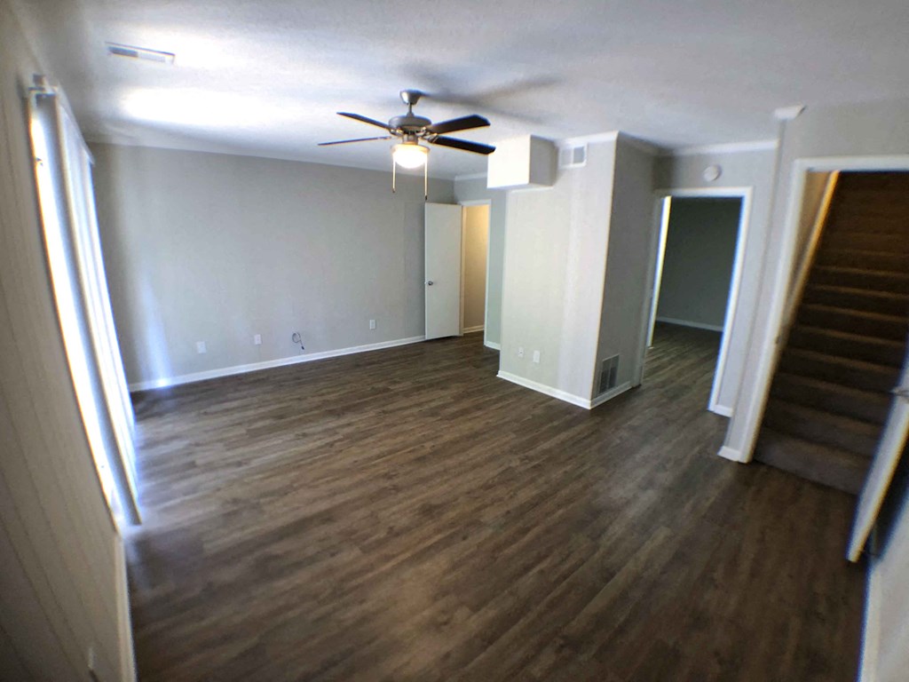 a living room with wood floors and a ceiling fan