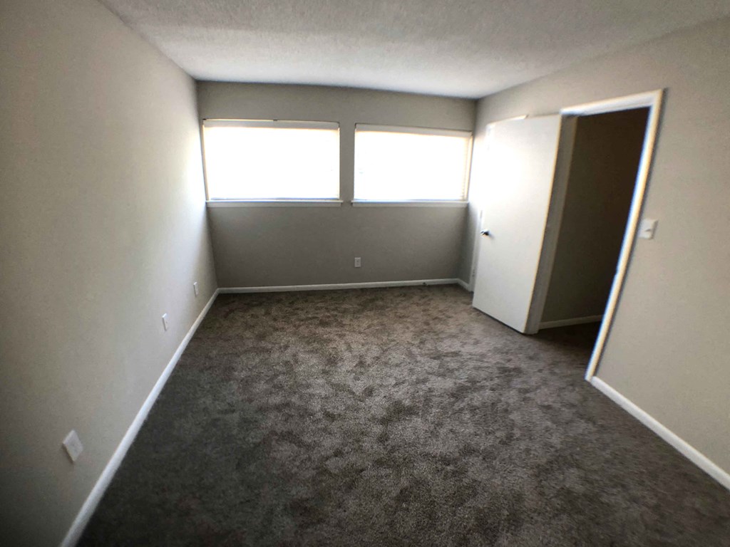 an empty room with a door and a window