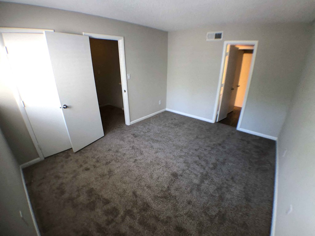 an empty room with white walls and a carpet