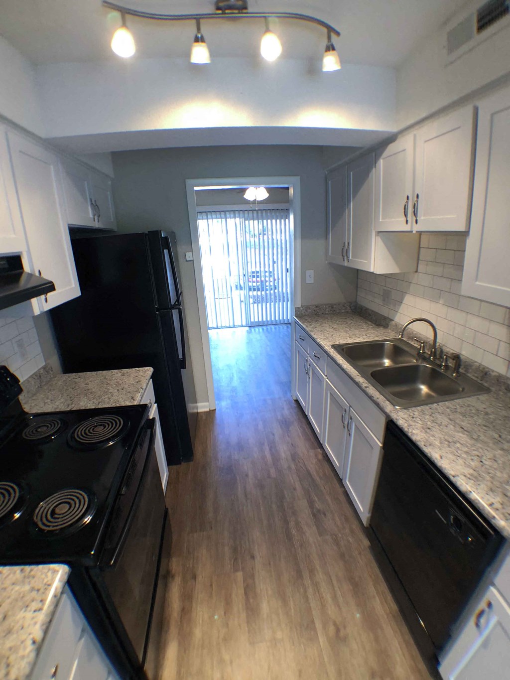a kitchen with black appliances and white cabinets