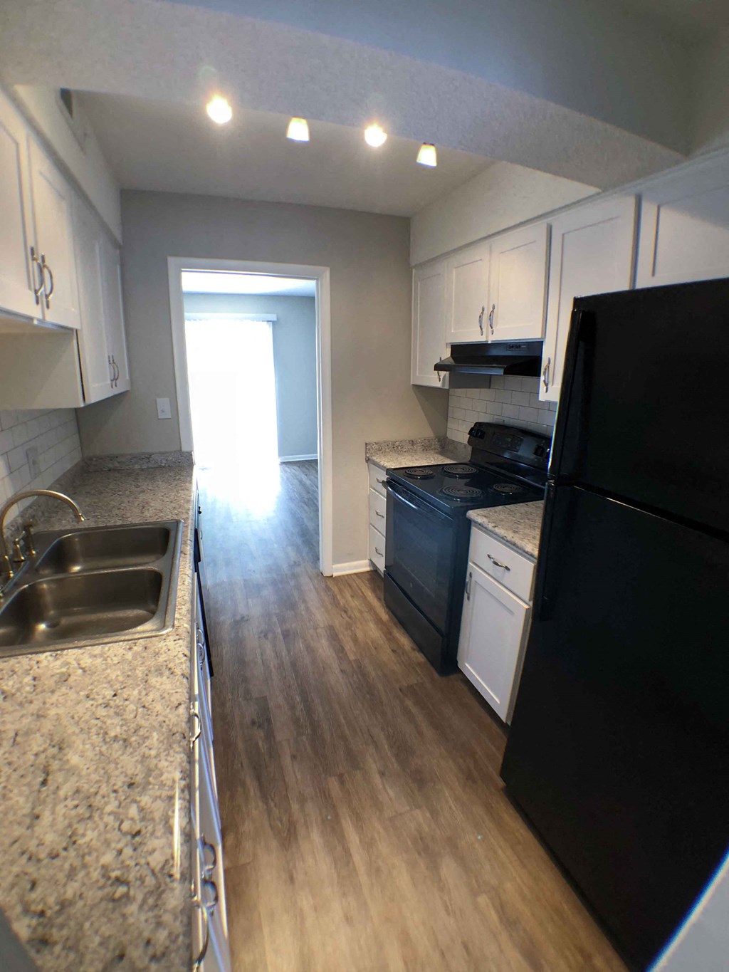 a kitchen with granite counter tops and black appliances