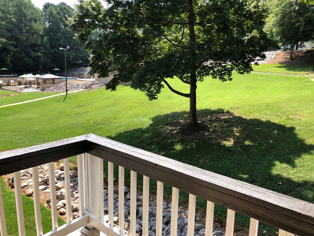 a view of a park from a balcony with a tree