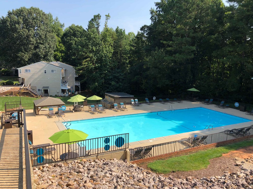 a swimming pool with umbrellas and chairs around it
