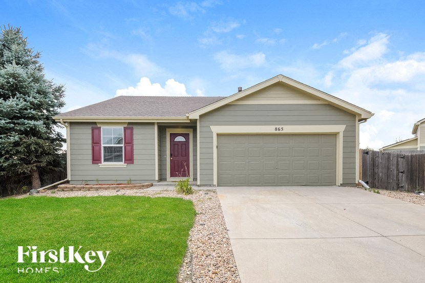 A house with a garage and a driveway in front of it.