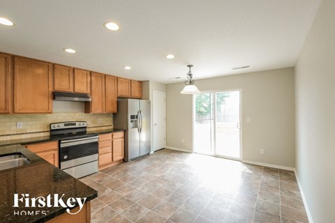 A kitchen with wooden cabinets and a tile floor.
