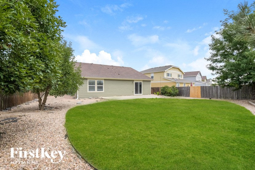 A house with a green lawn and a tree in front of it.