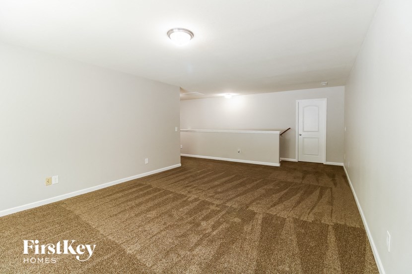 a empty living room with carpet and white walls
